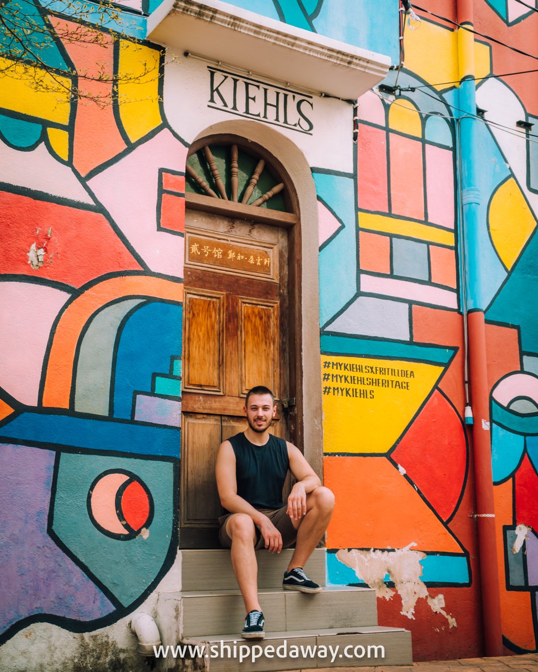Matej Span posing in front of the street art at Kiehl's Heritage in Melaka, Malaysia