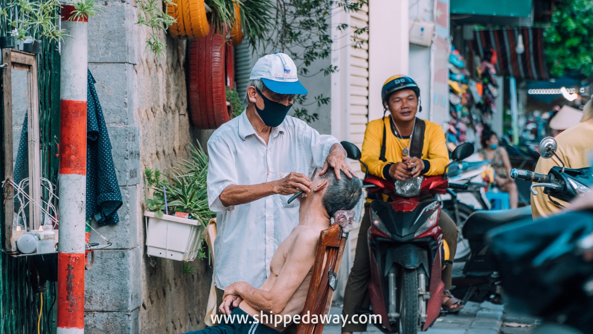 Man getting a shave on the streets of Hanoi's Old Quarter, Vietnam