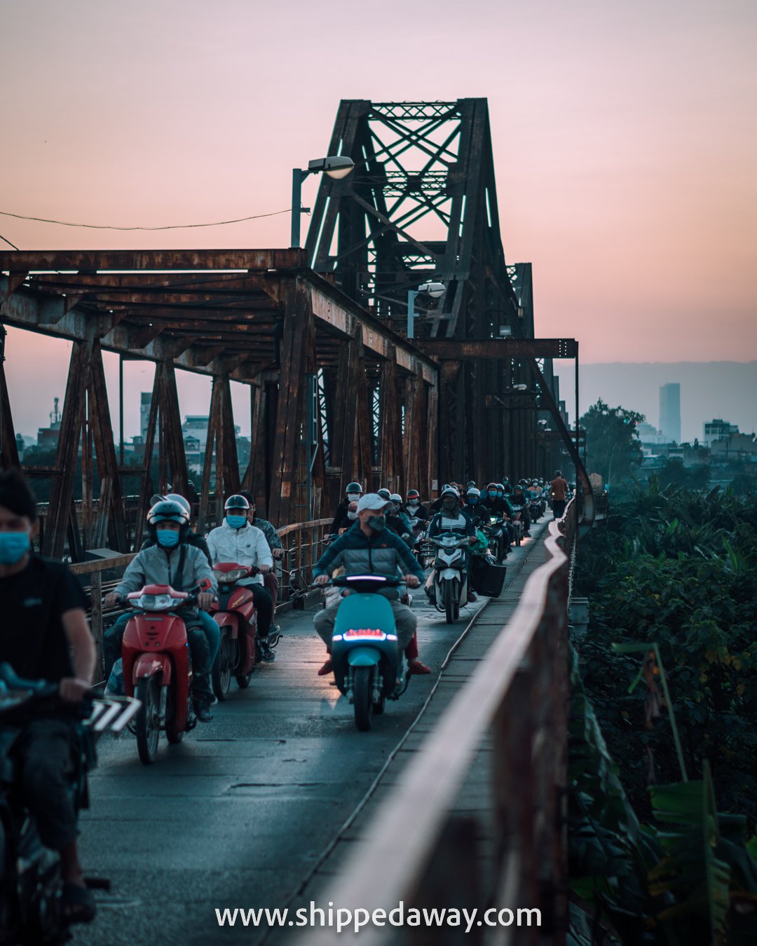 Bikes driving over the Long Bien Bridge at sunset, Hanoi, Vietnam