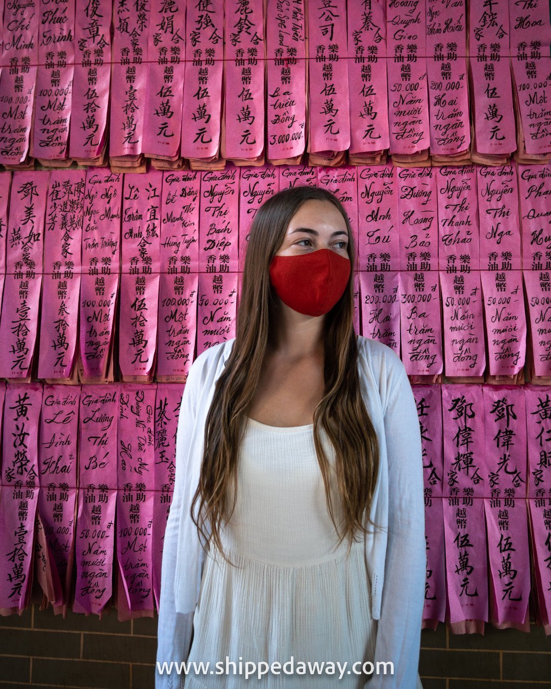 Arijana Tkalcec in front of pink donation notes at Thien Hau Pagoda, Ho Chi Minh City, Vietnam