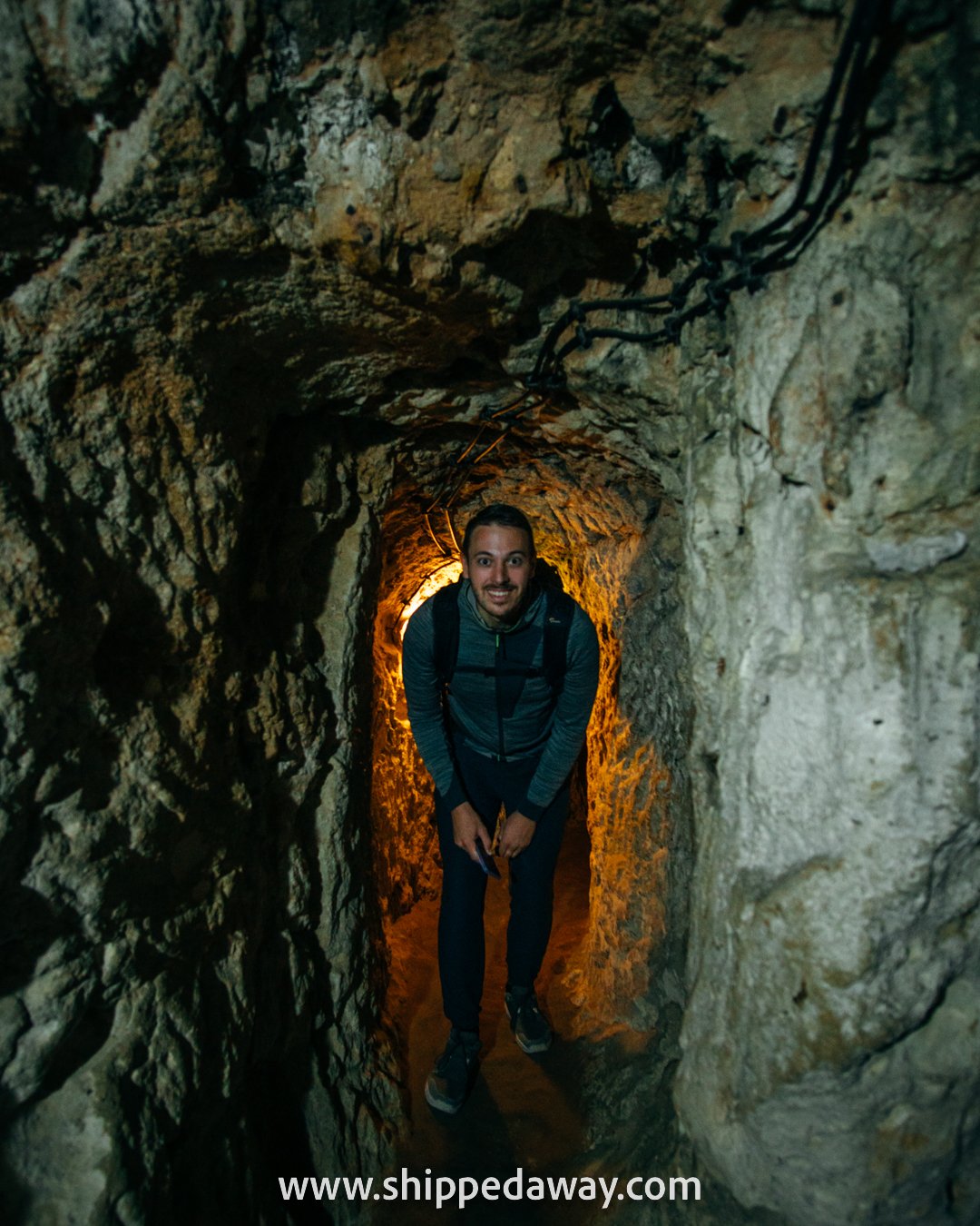 Matej Špan bent down, crouching through tunnels of Derinkuyu Underground City