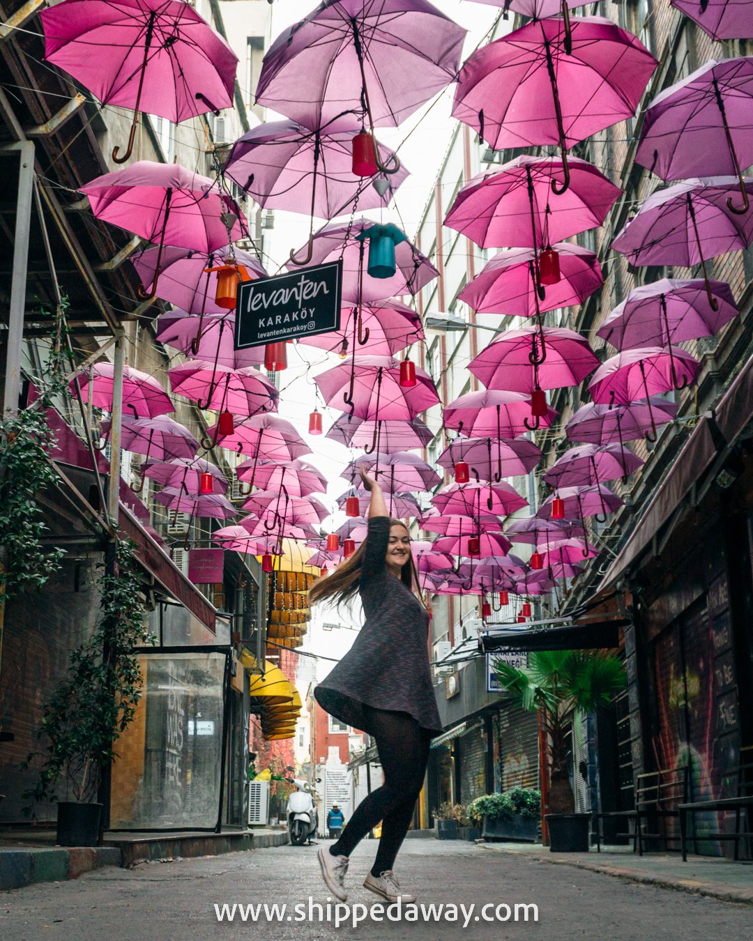 Arijana Tkalcec spinning under pink hanging umbrellas, Karakoy, Istanbul