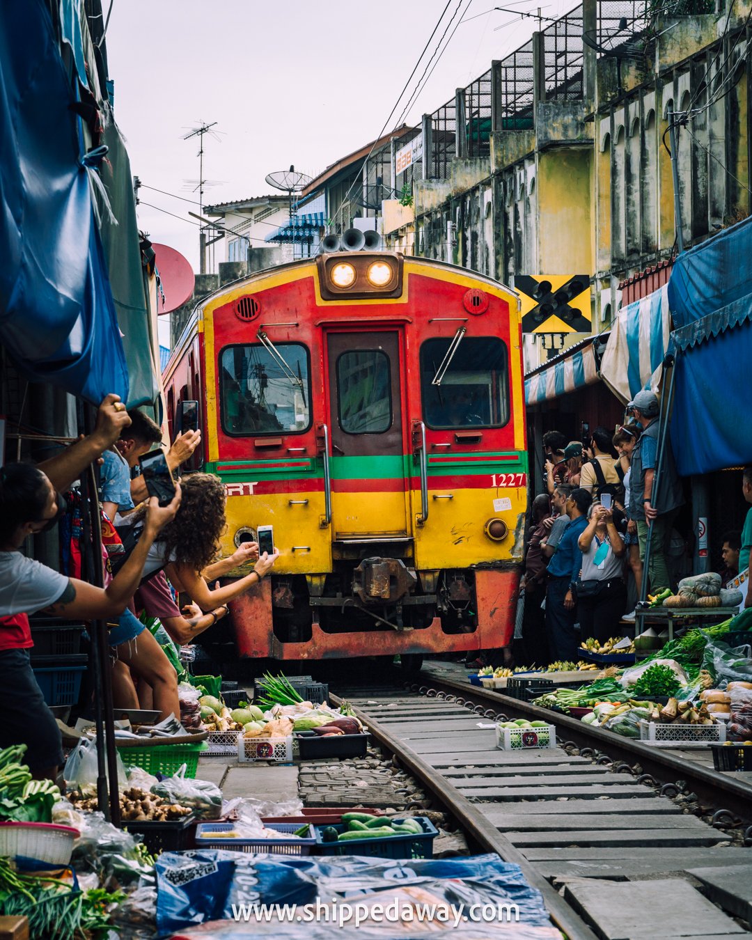 Train passing Maeklong Railway Market, Bangkok, Thailand