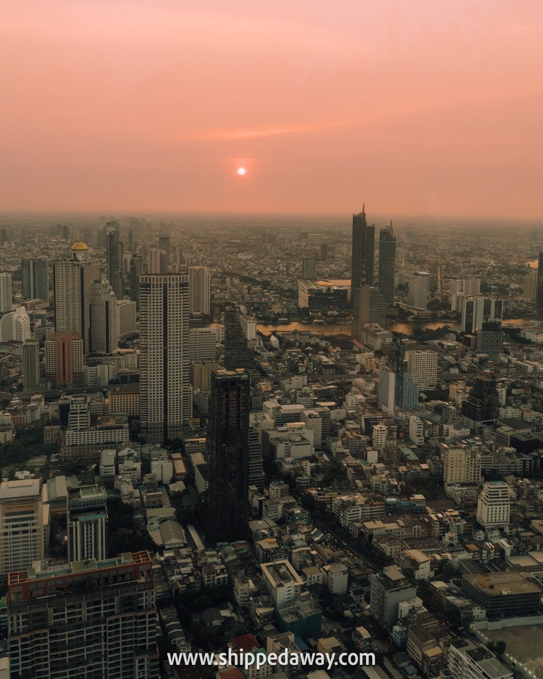 Panoramic Bangkok skyline at sunset from the outdoor rooftop of Mahanakhon Tower
