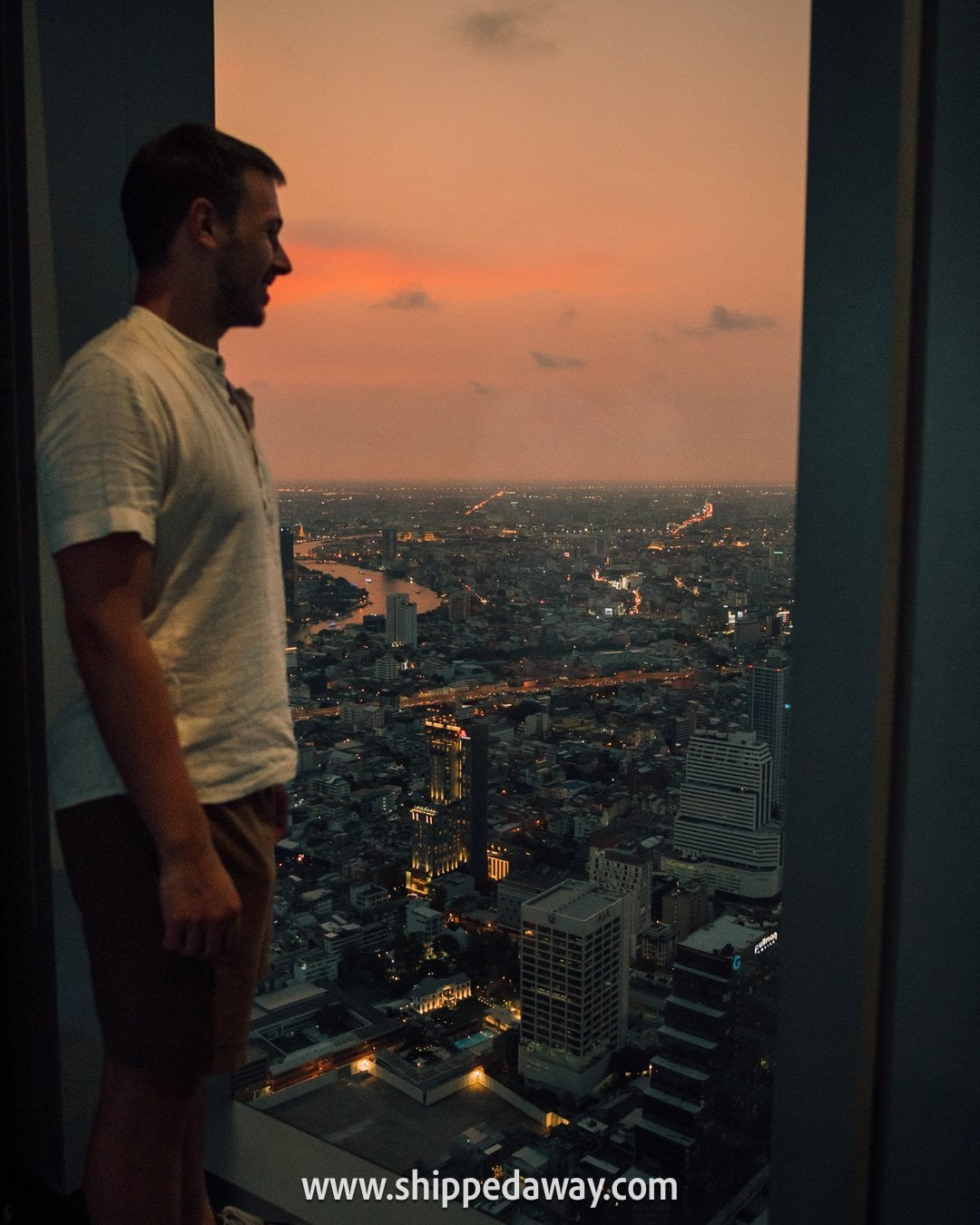 View at sunset from indoor Mahanakhon observation deck in Bangkok, Thailand