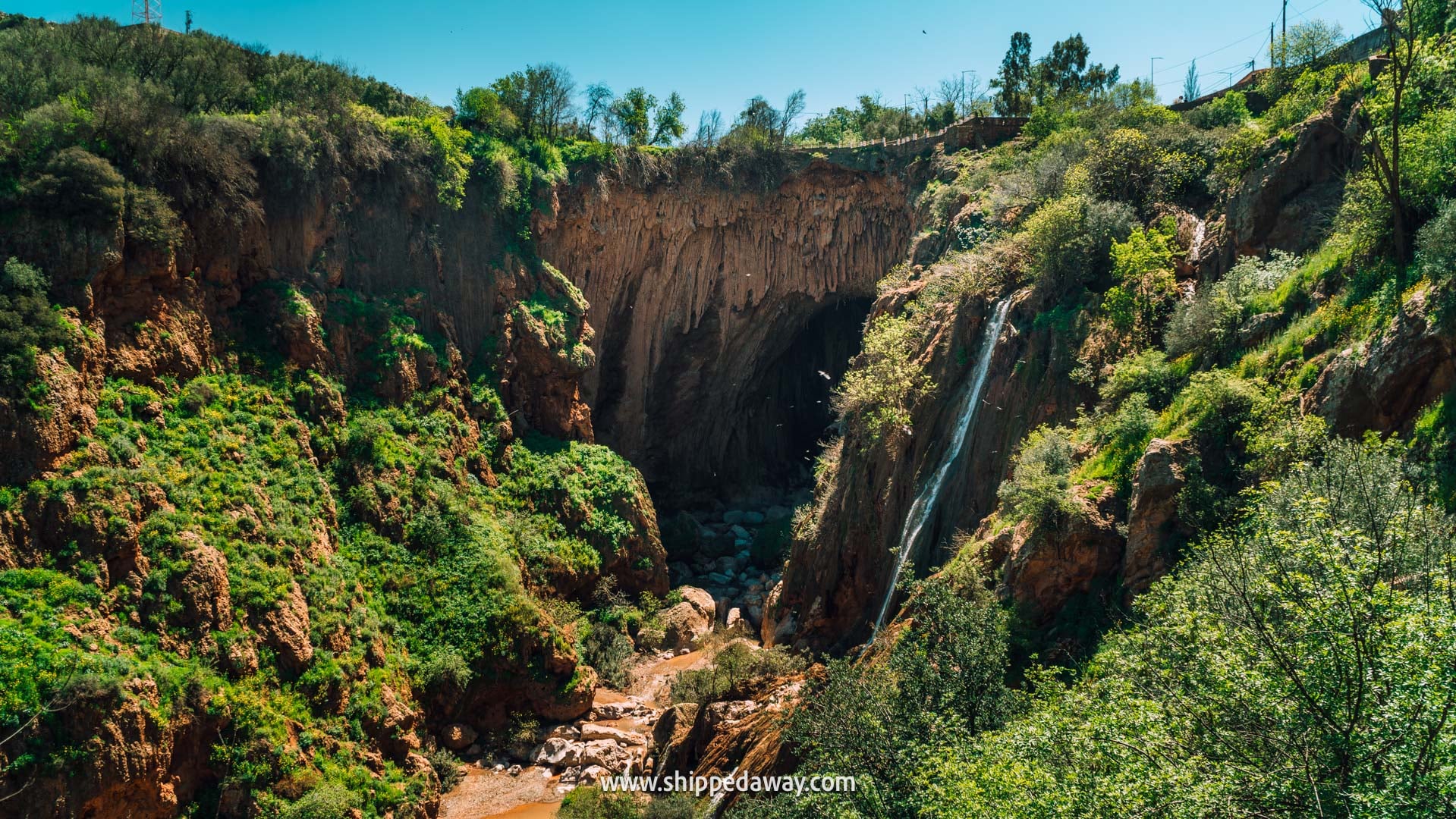 Our tips for visiting Iminifri Natural Bridge in Morocco - natural bridge and waterfall seen from the trail