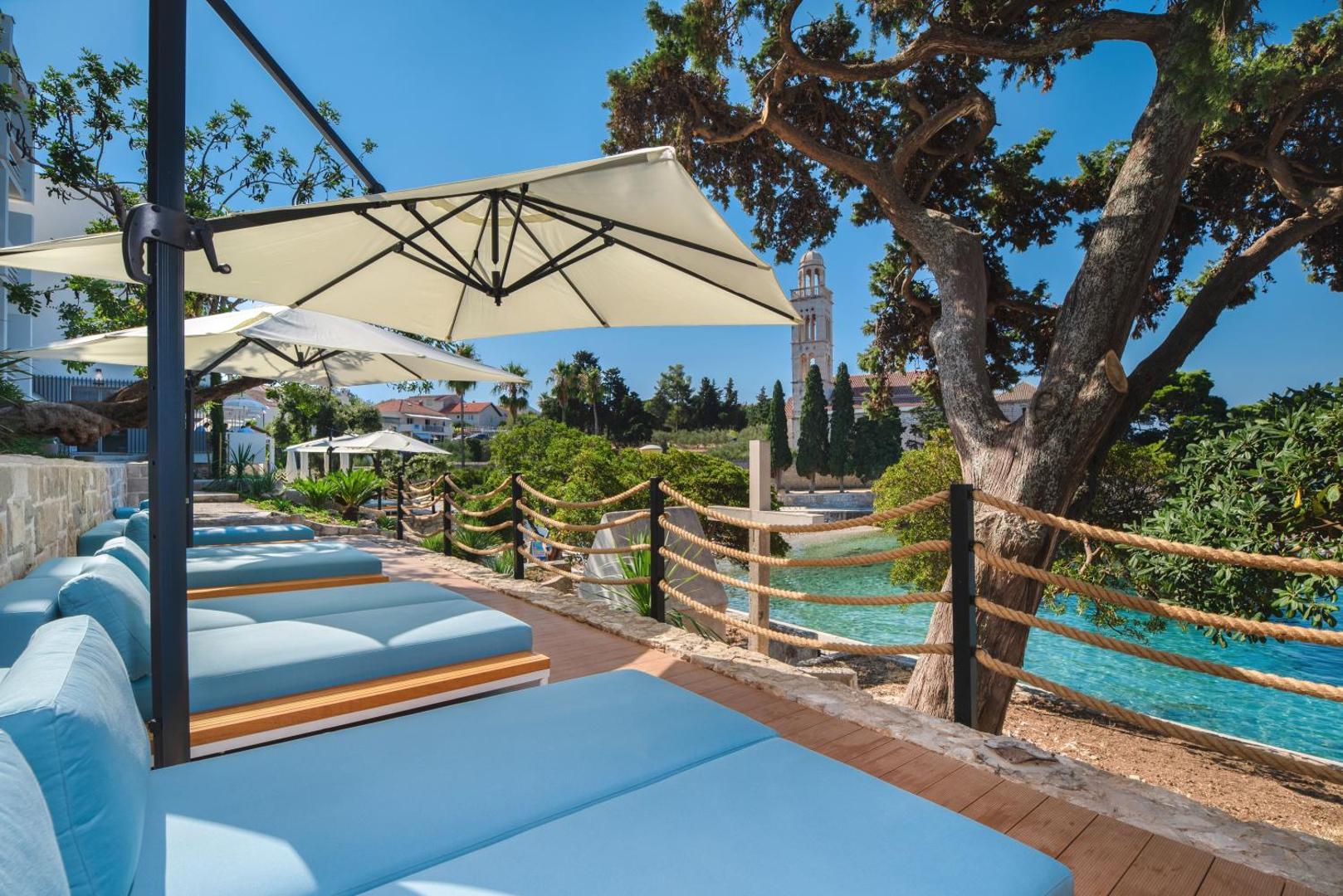 best Hvar town luxury hotels - our favorite luxury hotels to stay in Hvar town - sun loungers at Beach Bay Hotel above Franciscan Monastery Beach